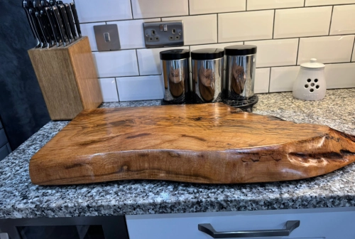 A sizable wooden block placed on a countertop, highlighting its rustic appearance and smooth surface